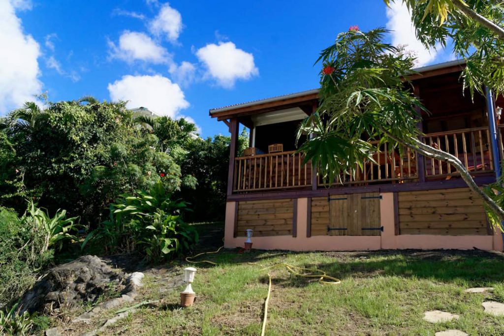 Le chalet en bois dans son jardin tropical